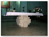 L'altare in lastre di travertino incastrate opera dello scultore Mimmo di Cesare.