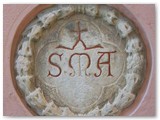 Castelnuovo - La via di Gabbro parte dalla Piazzetta del Magazzino dove si trova questo rosone con lo stemma 'S.M.A.' (Santa Maria Assunta)